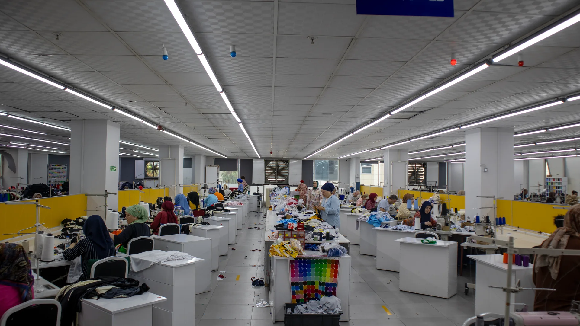 Wide view of the sewing floor with production lines running