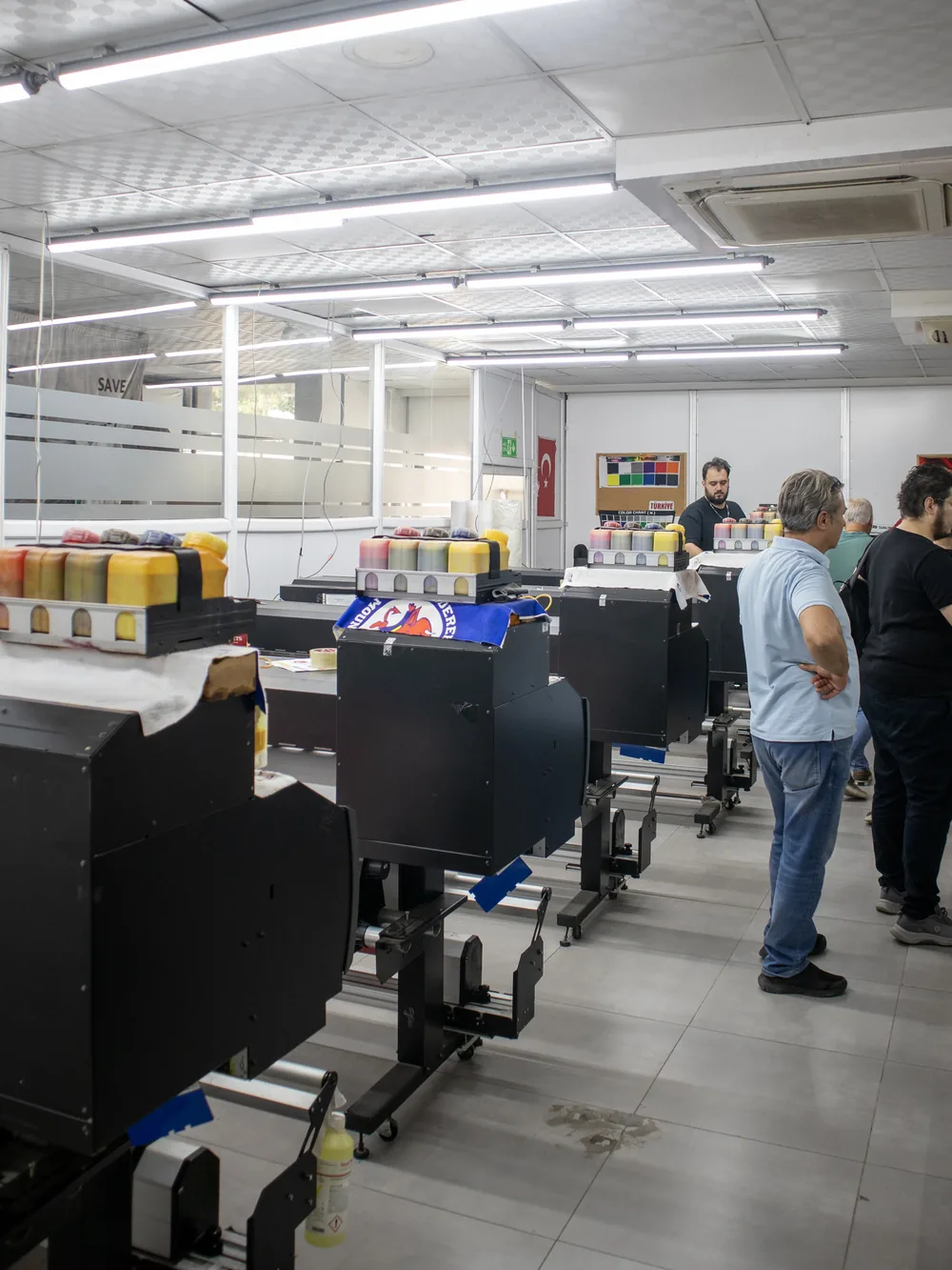 Row of large-format sublimation printers in the print room